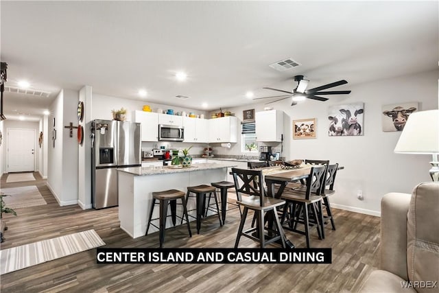 dining room featuring visible vents, a ceiling fan, wood finished floors, recessed lighting, and baseboards