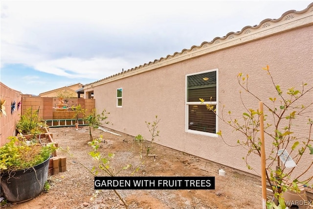 exterior space with a fenced backyard and stucco siding