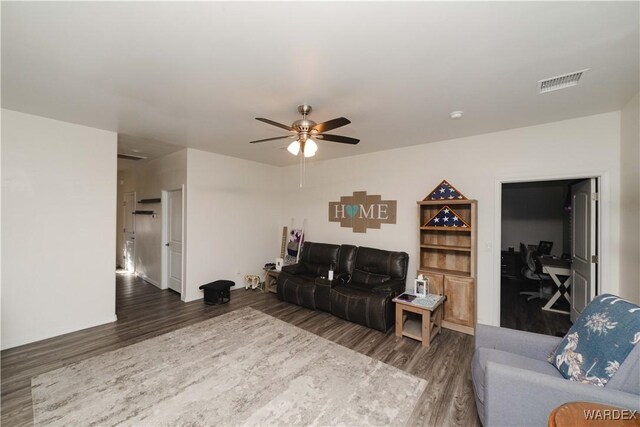 living room featuring dark wood-style floors, visible vents, and a ceiling fan