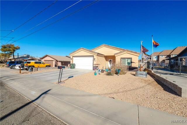 view of front facade with an attached garage, fence, driveway, a residential view, and stucco siding