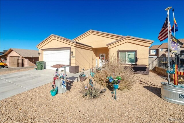 view of front of home featuring driveway, a garage, a tiled roof, fence, and stucco siding