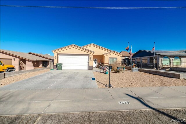 single story home featuring concrete driveway, an attached garage, and stucco siding