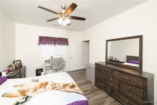 bedroom featuring a ceiling fan, visible vents, and wood finished floors