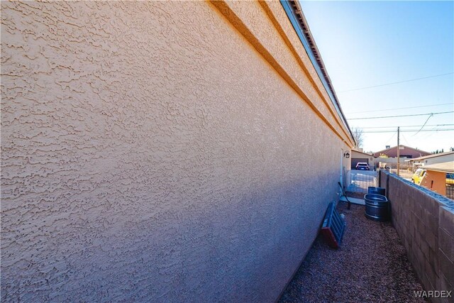 view of property exterior featuring fence and stucco siding