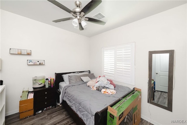 bedroom featuring baseboards, ceiling fan, visible vents, and dark wood-style flooring