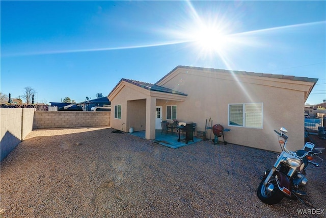 back of property with a patio area, a fenced backyard, and stucco siding