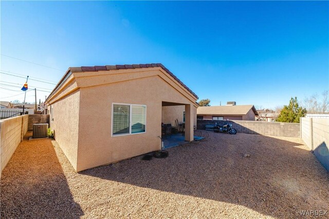 view of property exterior with central AC, a patio, a fenced backyard, and stucco siding