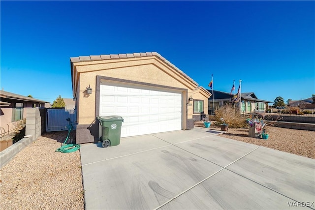 single story home with concrete driveway, fence, an attached garage, and stucco siding