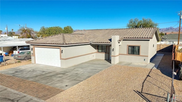 view of front of home featuring a tile roof, stucco siding, concrete driveway, an attached garage, and fence