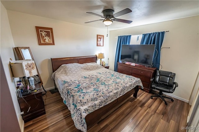 bedroom featuring dark wood-style flooring, a ceiling fan, and baseboards