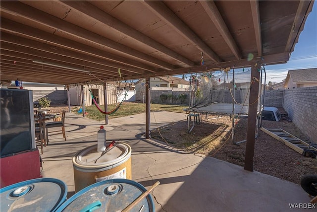 view of patio with a trampoline and a fenced backyard