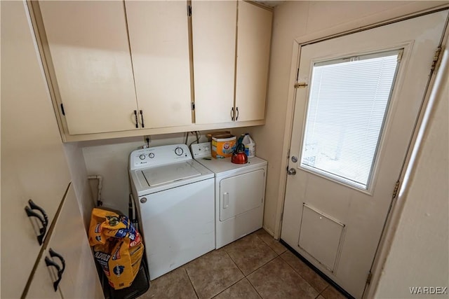 laundry room with washer and clothes dryer, cabinet space, and tile patterned floors