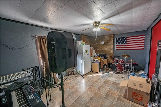 miscellaneous room featuring brick wall and a ceiling fan