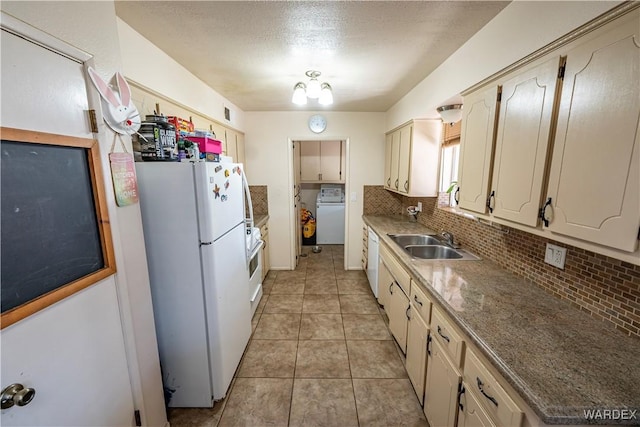 kitchen featuring light tile patterned floors, backsplash, a sink, washer / dryer, and white appliances