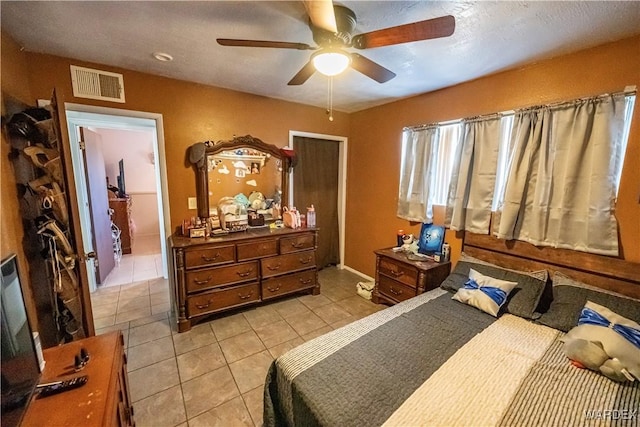 bedroom featuring a ceiling fan, visible vents, and light tile patterned floors