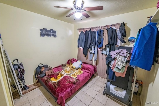 bedroom with ceiling fan, a textured ceiling, and light tile patterned flooring