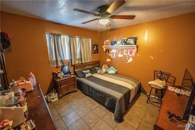 bedroom with a ceiling fan, a textured ceiling, and light tile patterned floors