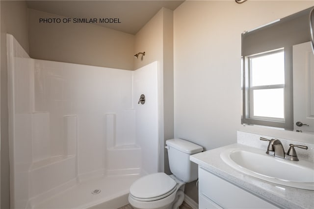 bathroom with a shower, vanity, and toilet