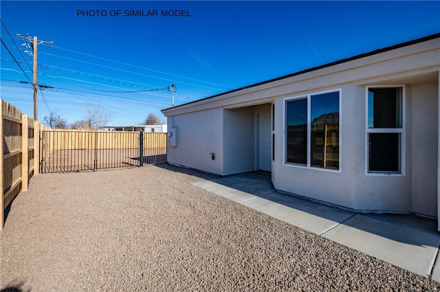 exterior space featuring stucco siding, a fenced backyard, and a patio