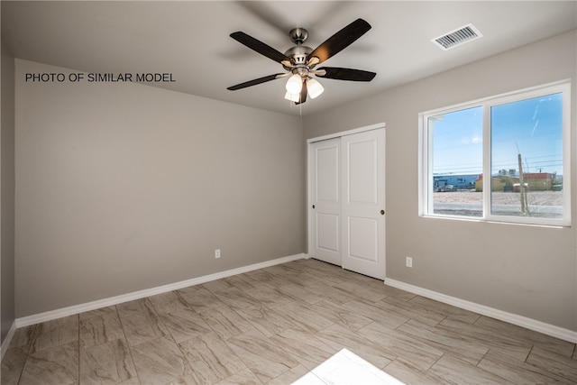 unfurnished room with baseboards, ceiling fan, and visible vents