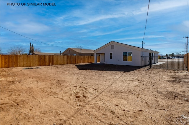 view of property exterior with stucco siding and a fenced backyard