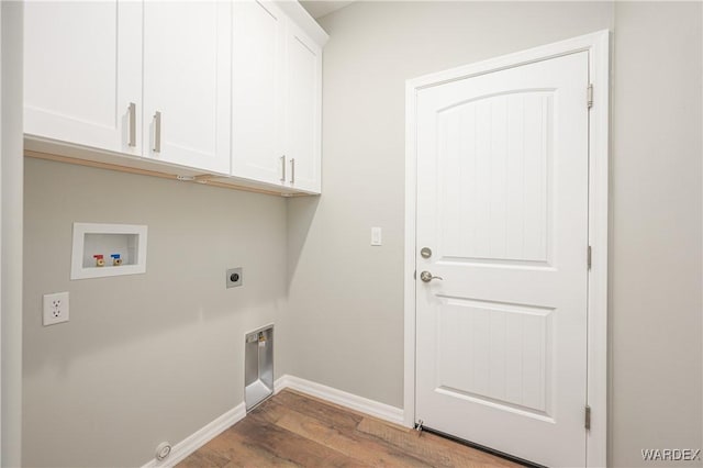 clothes washing area with hookup for an electric dryer, washer hookup, wood finished floors, baseboards, and cabinet space