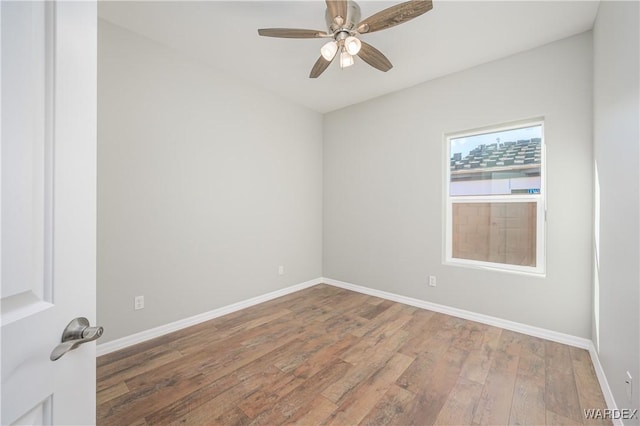 spare room with a ceiling fan, baseboards, and wood finished floors