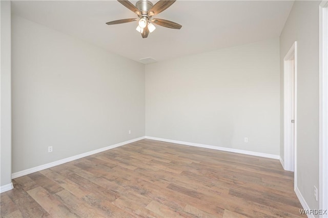 unfurnished room with a ceiling fan, baseboards, and wood finished floors