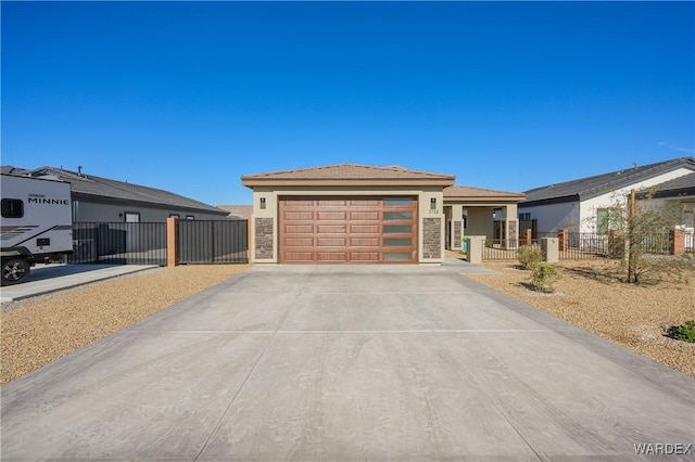 prairie-style house featuring driveway, an attached garage, fence, and stucco siding