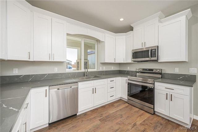 kitchen featuring white cabinetry, stainless steel appliances, and a sink