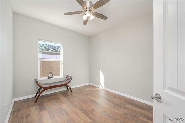 empty room with ceiling fan, baseboards, and wood finished floors