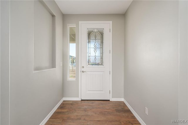 doorway with baseboards and wood finished floors