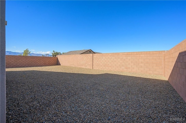 view of yard with a fenced backyard and a mountain view