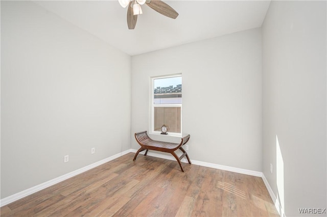 spare room with ceiling fan, baseboards, and wood finished floors