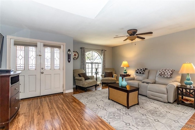 living area with ceiling fan, baseboards, and wood finished floors