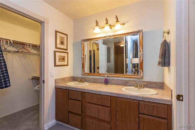 bathroom with a sink, a spacious closet, and double vanity