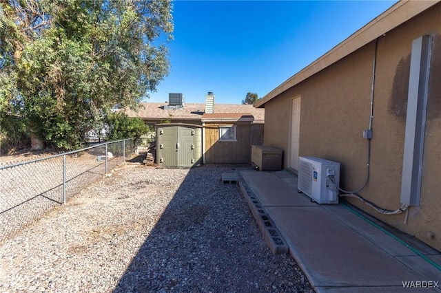 view of yard featuring a fenced backyard, an outbuilding, a storage unit, cooling unit, and ac unit