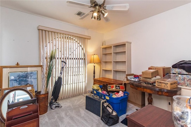 home office featuring carpet, visible vents, and a ceiling fan