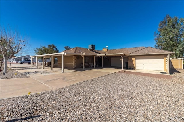 ranch-style house with a garage and gravel driveway