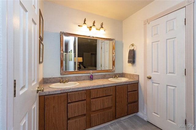 full bath featuring a sink, ensuite bathroom, and double vanity