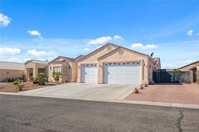 view of front of property featuring a garage, concrete driveway, and stucco siding