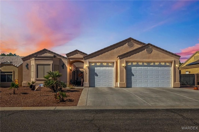 ranch-style house featuring concrete driveway, an attached garage, and stucco siding