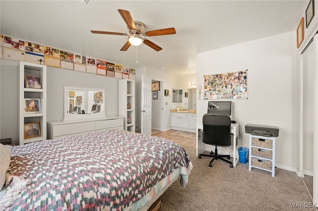 bedroom with a ceiling fan, light colored carpet, connected bathroom, and baseboards