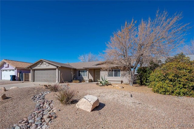 ranch-style home with a garage, driveway, and stucco siding