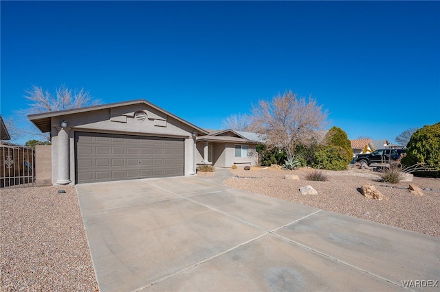 single story home featuring a garage, concrete driveway, fence, and stucco siding