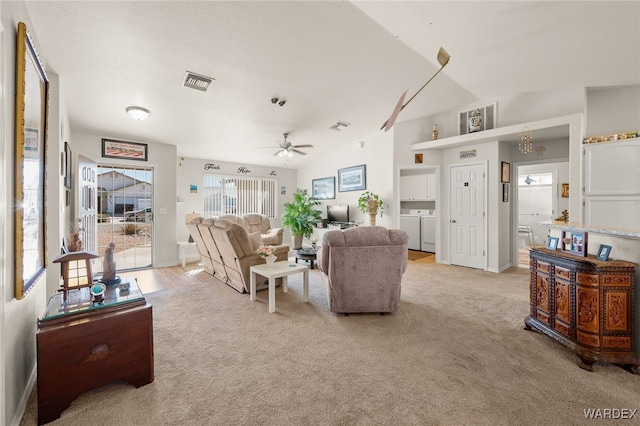 living area with lofted ceiling, washing machine and dryer, light colored carpet, a ceiling fan, and visible vents