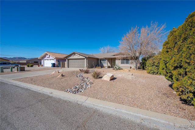 ranch-style house with concrete driveway and an attached garage