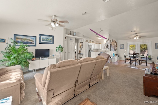 living room with a ceiling fan, lofted ceiling, visible vents, and light carpet