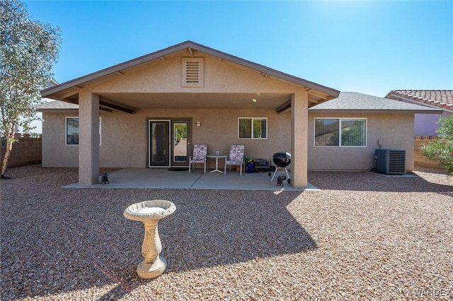 rear view of property with central AC, a patio area, fence, and stucco siding