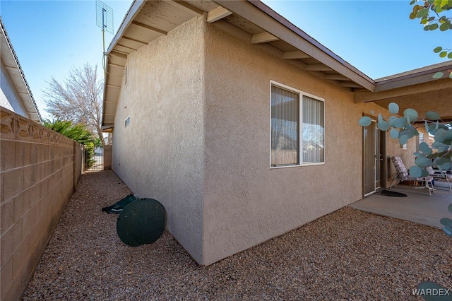 view of home's exterior featuring fence and stucco siding